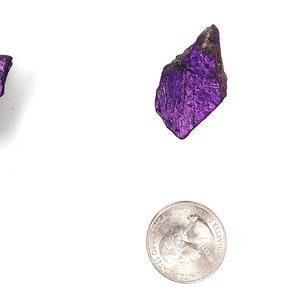 Pode incluir: Tr&ecirc;s peda&ccedil;os de mica iridescente roxa, cada um do tamanho de uma moeda de 25 centavos de d&oacute;lar americano.