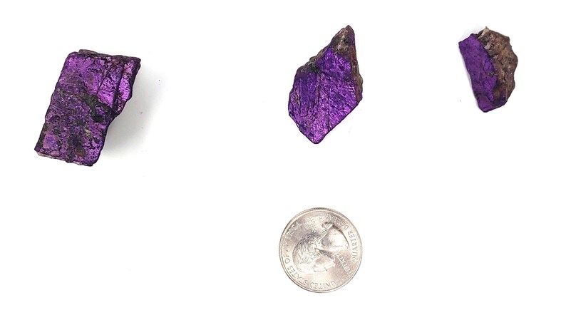 Pode incluir: Tr&ecirc;s peda&ccedil;os de mica iridescente roxa, cada um do tamanho de uma moeda de 25 centavos de d&oacute;lar americano.