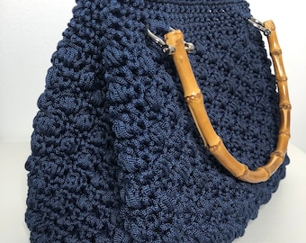 Handmade crochet bag made of cord with bamboo handles and leather base.