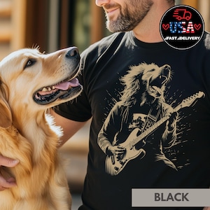 Op de afbeelding: Een zwart T-shirt met een afbeelding van een golden retriever die elektrische gitaar speelt. De hond draagt een bandana en heeft een lange manen. De tekst "BLACK" is onderaan het shirt gedrukt.