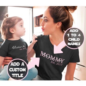 以下が含まれることがあります： ピンクの文字が入った黒いTシャツ2枚。大きい方のTシャツには「Mommy Est. 2017」と書いてあり、小さい方のTシャツには「Olivia Est. 2017」と書いてあります。
