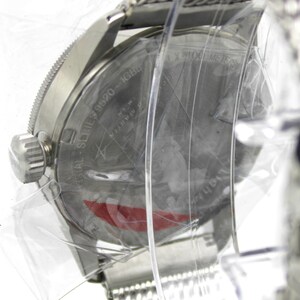 K&ouml;nnte beinhalten: Eine silberne Uhr mit einem Edelstahlband. Das Zifferblatt der Uhr ist mit einer durchsichtigen Plastikabdeckung versehen. Auf der R&uuml;ckseite der Uhr ist der Text "AL SERIES 19920 MADE IN JAPAN" eingraviert.