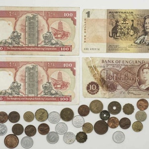 Könnte beinhalten: Eine Sammlung von alten Banknoten und Münzen. Die Banknoten umfassen eine 100-Hongkong-Dollar-Note, eine 1-Australische-Dollar-Note und eine 10-Schilling-Note der Bank of England. Die Münzen sind eine Mischung aus britischem und australischem Geld.