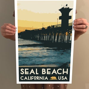 Puede incluir: Un cartel de viaje de estilo vintage con la silueta de un muelle que se extiende hacia el oc&eacute;ano al atardecer. El texto "SEAL BEACH CALIFORNIA USA" est&aacute; impreso en la parte inferior del cartel.