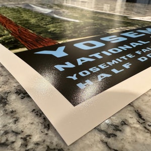 Może przedstawiać: Plakat w stylu vintage z czarnym tłem i białym tekstem. Tekst brzmi "Yosemite National Park, Yosemite Falls, Half Dome". Tekst jest w jasnoniebieskim kolorze. Plakat ma białą ramkę.