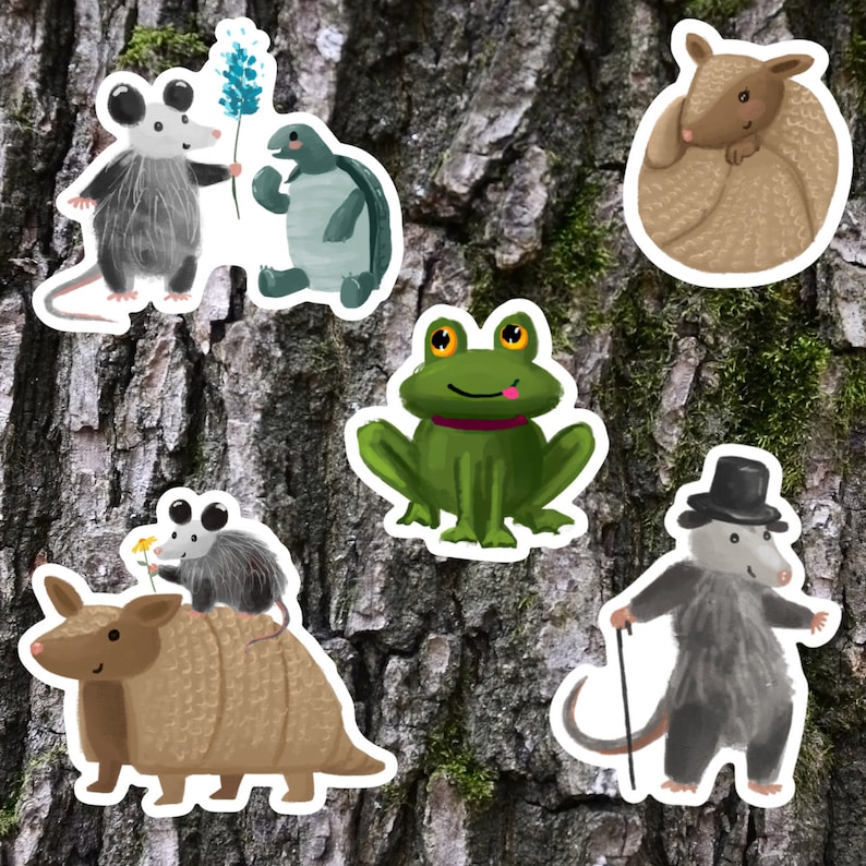May include: A set of five colorful animal stickers featuring a green frog, a brown armadillo, a gray opossum, a brown and gray opossum, and a brown turtle.