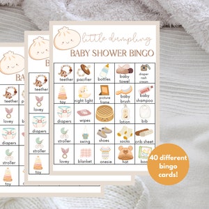 May include: A set of 40 printable baby shower bingo cards with a cute dumpling illustration. The cards feature various baby-related items like diapers, pacifiers, and toys. The text "little dumpling baby shower bingo" is at the top of the card.