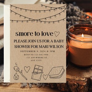 May include: A brown paper baby shower invitation with the text "smore to love" and a heart. The invitation includes details for a baby shower for Mari Wilson on September 9, 2024 at 5 PM. The invitation also includes a graphic of a s'more with a marshmallow, chocolate bar, and graham cracker.