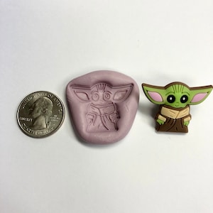 May include: A purple silicone mold for making a small green and brown character with large ears. The character is similar to the popular Star Wars character, Baby Yoda.