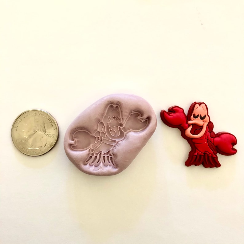 Pu&ograve; includere: Uno stampo in silicone e una statuetta di plastica rossa di Sebastian il granchio del film Disney La Sirenetta. Lo stampo &egrave; di colore lilla chiaro e la statuetta &egrave; circa delle dimensioni di una moneta da 25 centesimi di euro.