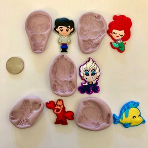 Pu&ograve; includere: Set di 10 stampi in silicone con personaggi del film Disney La Sirenetta. Gli stampi sono viola, rosa e grigi e presentano personaggi come Ariel, Ursula, il principe Eric e Sebastian.