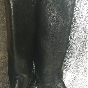 May include: A pair of black leather boots with a tall shaft and a pointed toe.