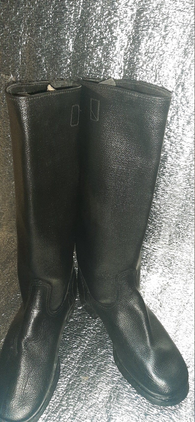 May include: A pair of black leather boots with a tall shaft and a pointed toe.