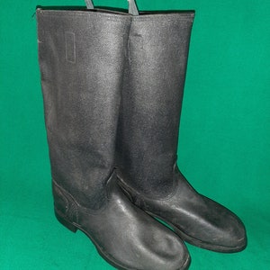 May include: A pair of black leather boots with a zip on the side. The boots are tall and have a rounded toe.