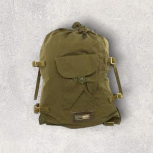 Może przedstawiać: Zielony plecak z płótna z sznurkiem do ściągania, dużą kieszenią z klapą i regulowanymi paskami.