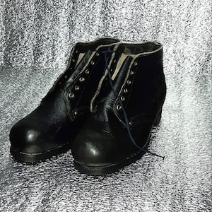 Botas vintage de cuero negro con cordones, altura clásica hasta el tobillo, calzado de la vieja escuela.