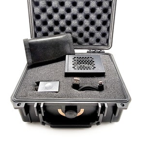 Könnte beinhalten: Ein schwarzer Hartschalenkoffer mit Schaumstoff-Innenausstattung. Der Koffer enthält einen schwarzen Lüfter, ein schwarzes Netzteil, ein schwarzes Kabel und eine schwarze Tasche.