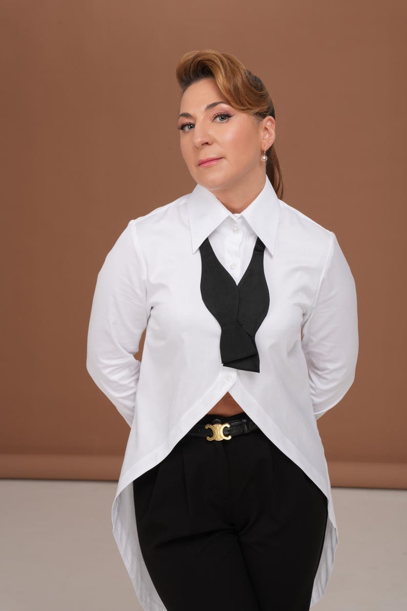 Hero image of white blouse: tuxedo shirt women with high collar shirt silhouette, long tailcoat back, and French cuffs for cufflinks; timeless business blouse and elegant evening top.