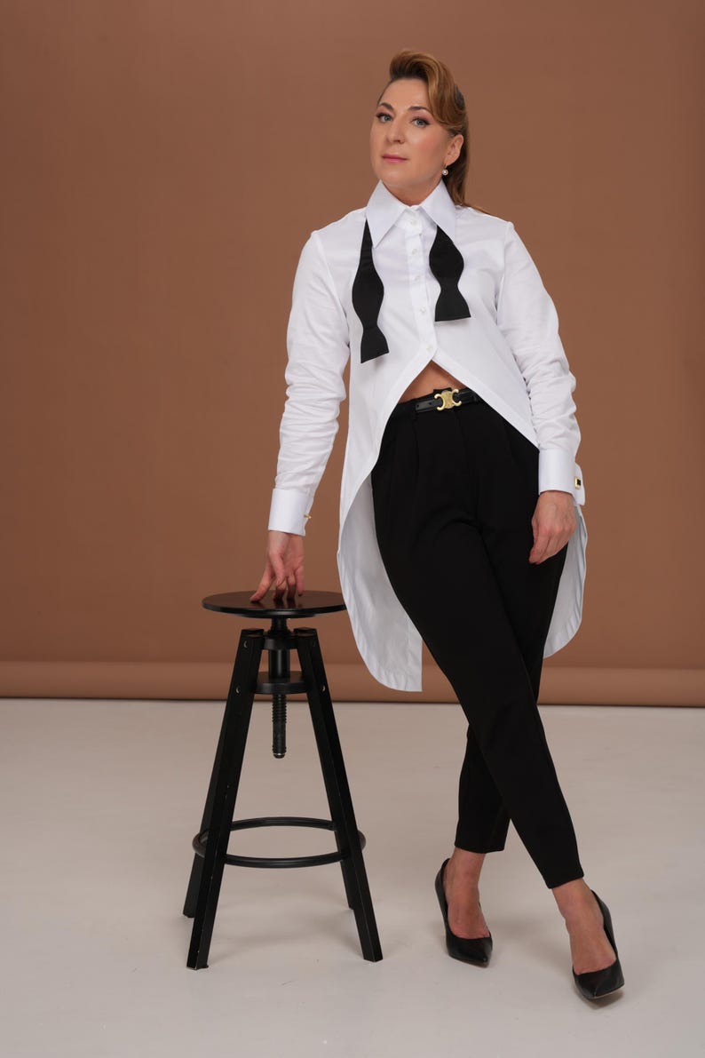 Full-length editorial styling of tuxedo shirt women with long back tailcoat effect; business blouse and evening statement top in one piece.