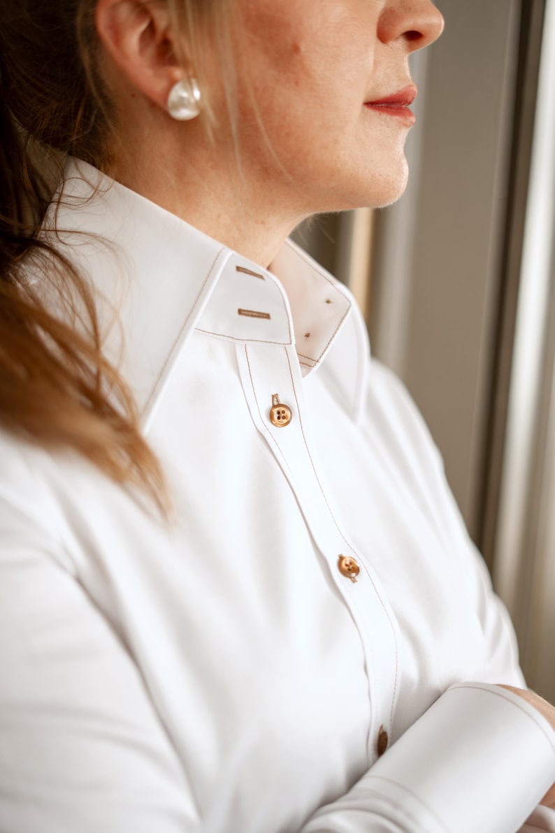 Close-up of the brown designer buttons and precise topstitching along the placket. The fine contrast stitching adds depth and character to the high-quality stretch cotton fabric. This shirt is a true example of expert craftsmanship and timeless elegance.