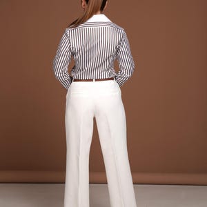 Back view highlighting the precise tailoring and perfect fit of the women’s striped dress shirt with French cuffs. The contrast between the chocolate brown stripes and white collar reflects timeless elegance. Designed for women who value luxury, quality, and comfort in a button down business shirt. Perfect for executive settings, meetings, or elevated everyday wear.