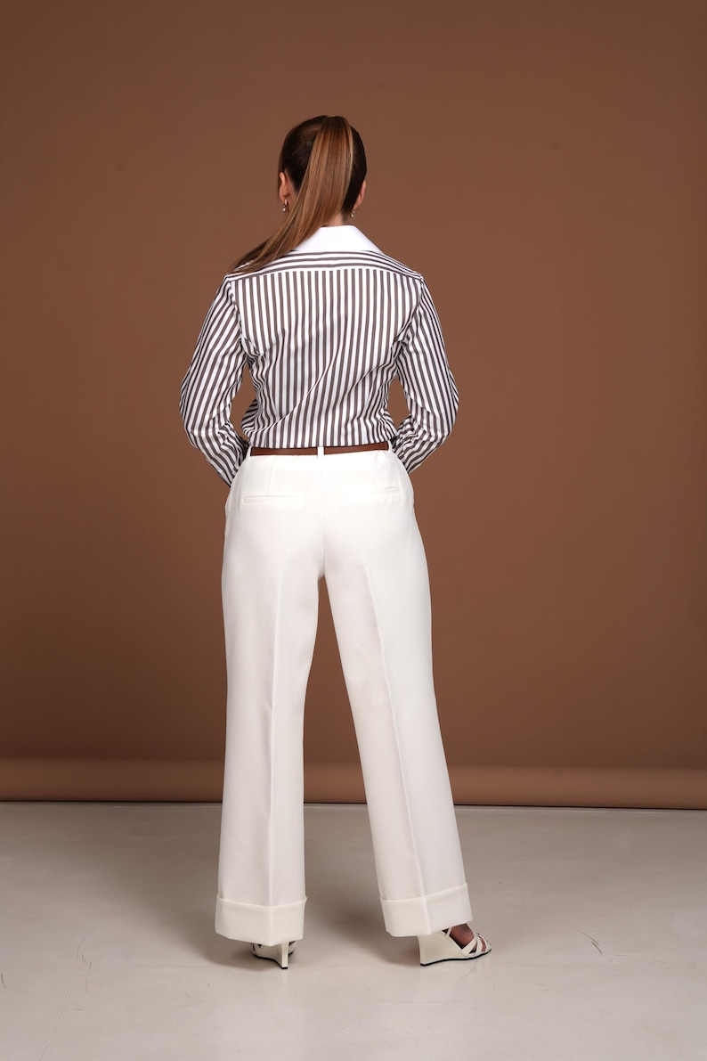 Back view highlighting the precise tailoring and perfect fit of the women’s striped dress shirt with French cuffs. The contrast between the chocolate brown stripes and white collar reflects timeless elegance. Designed for women who value luxury, quality, and comfort in a button down business shirt. Perfect for executive settings, meetings, or elevated everyday wear.