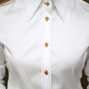 Zoomed-in view of the high collar structure, revealing expert tailoring and firm construction. The brown topstitching along the edge adds a modern contrast to the pristine white fabric, showcasing luxurious craftsmanship.