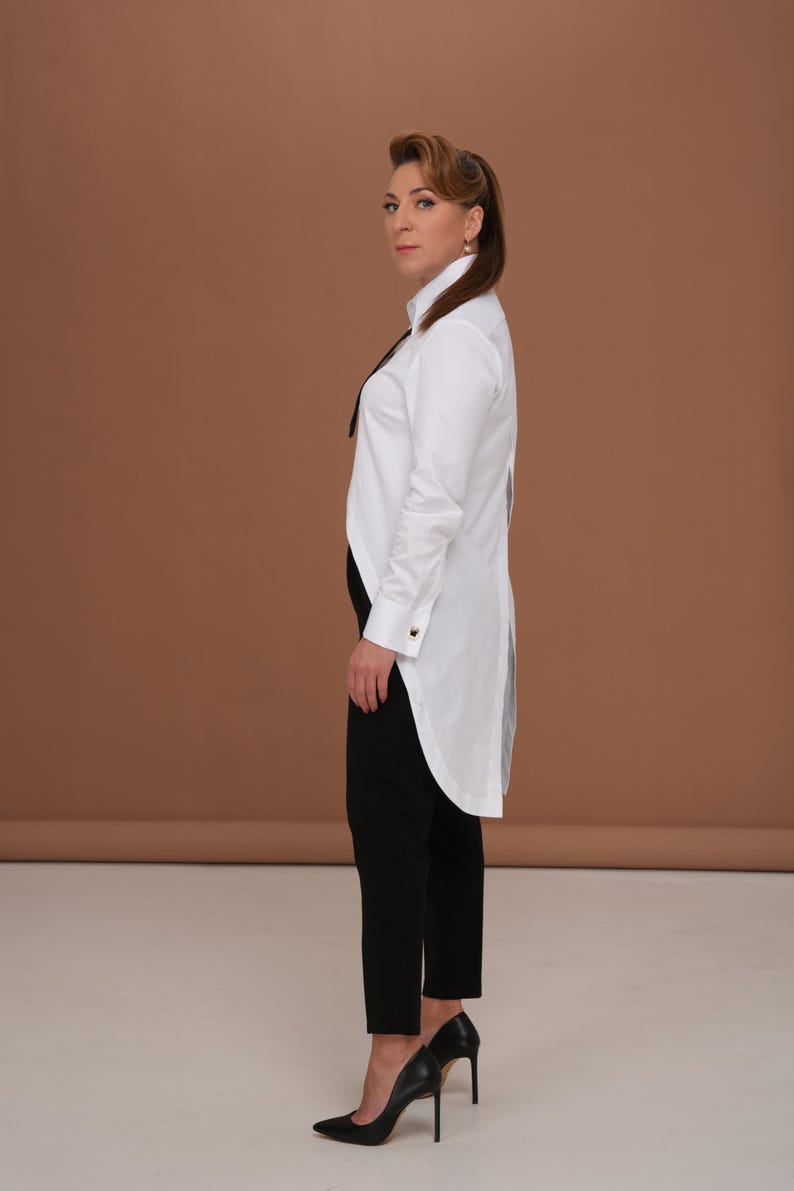 Hero image of white blouse: tuxedo shirt women with high collar shirt silhouette, long tailcoat back, and French cuffs for cufflinks; timeless business blouse and elegant evening top.
