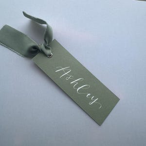 Cartão de nome de lugar com caligrafia e fita de chiffon verde EUCALIPTO + SÁLVIA | Cartão de nome de lugar branco personalizado | Ilhós dourados | Plano de assentos para casamento