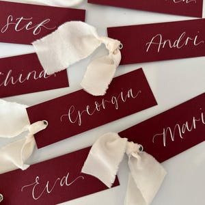 Kalligrafie bruiloft plaatsnaamkaart | Bordeauxrode kaart met champagne crème chiffon kalligrafie chiffon lint bordeauxrode plaatskaart Aangepast