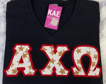 Gold Glitter Stars Greek Letters with Red Glitter Border on Black V-Neck