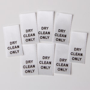 May include: Nine white satin fabric labels with black text that reads "Dry Clean Only".