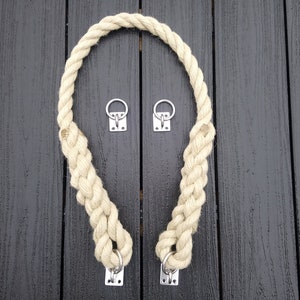 May include: A thick, braided rope loop with two metal rings and four metal clasps. The rope is beige and the clasps are silver.