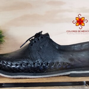 May include: Black leather shoes with a woven design on the sole. The shoes have a lace-up closure and a rounded toe. The brand name "COLORES DE M&Eacute;XICO MX" is printed on the shoe.