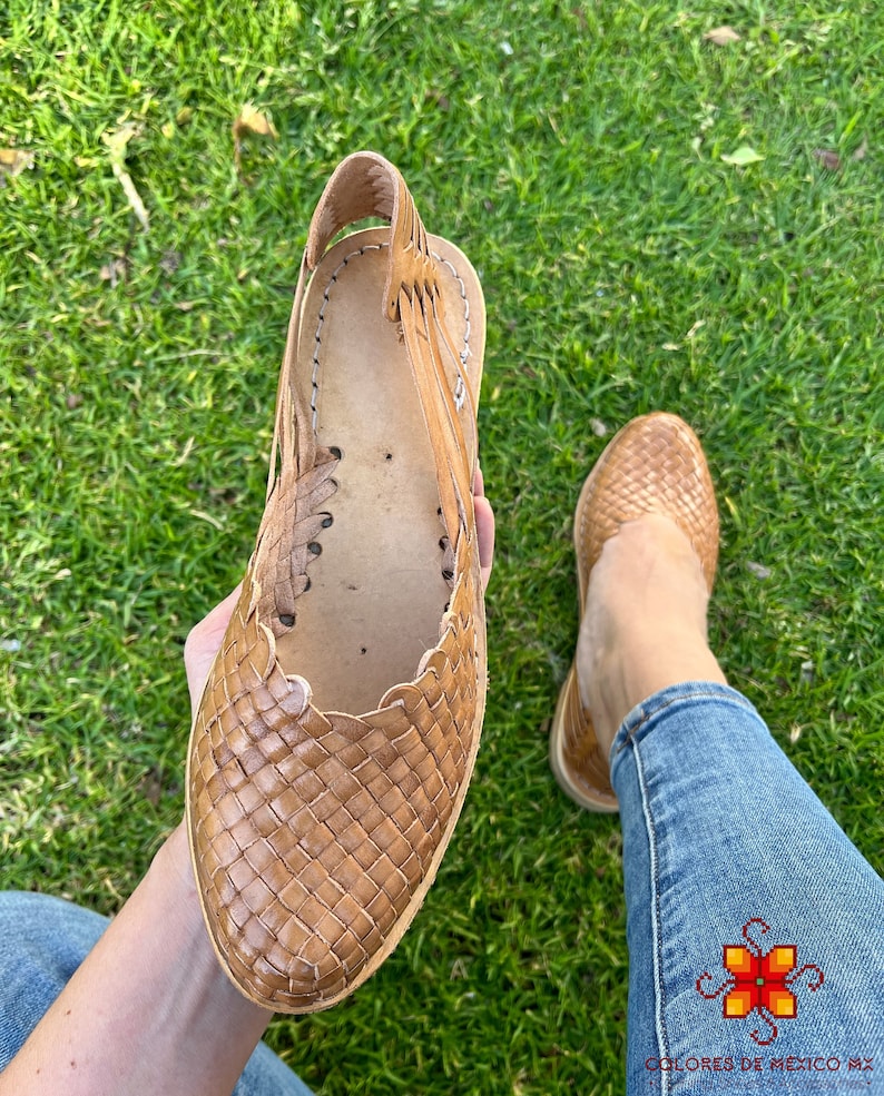 Puede incluir: Un par de sandalias de cuero tejido en color marr&oacute;n claro. Las sandalias tienen una correa que va alrededor del tobillo y un dise&ntilde;o tejido en la parte superior del pie.