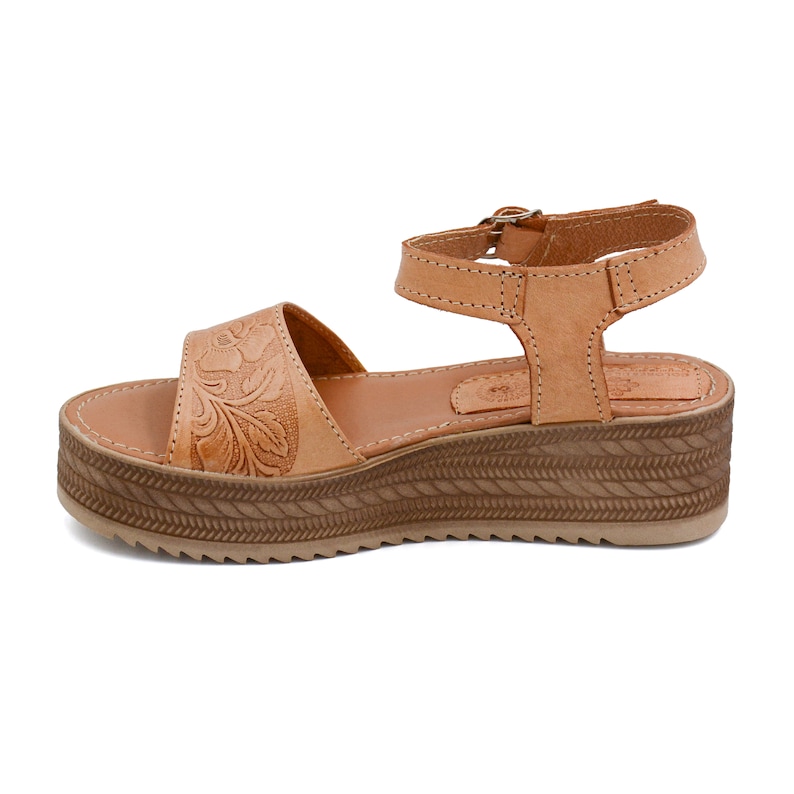Peut inclure: Sandales en cuir tann&eacute; avec un motif floral sur la bride et une &eacute;paisse semelle plateforme tress&eacute;e.