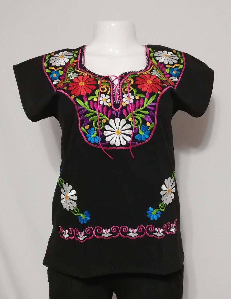 May include: Black embroidered blouse with colorful floral designs. The neckline features a pink tie closure. The embroidery includes white, pink, red, blue, and green thread.