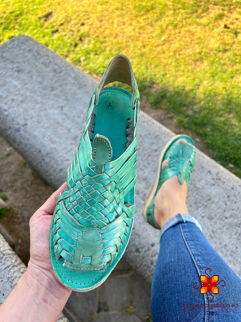 Puede incluir: Un par de sandalias de cuero turquesa con tiras tejidas. Las sandalias son hechas a mano y tienen un ajuste c&oacute;modo.