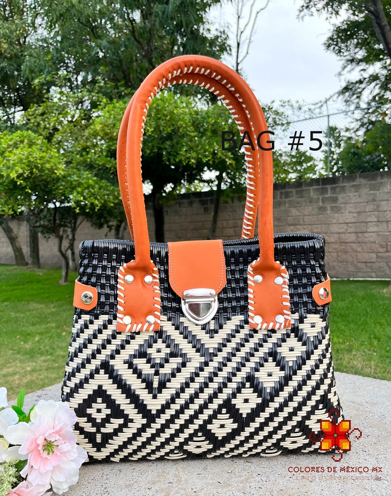 May include: A black and white woven tote bag with orange leather handles and a silver clasp. The bag has a geometric pattern and the text "BAG #5" is visible in the image.