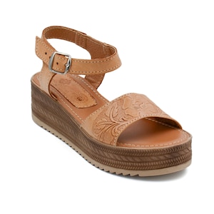 Peut inclure: Sandales en cuir tann&eacute; avec un motif floral et une &eacute;paisse semelle plateforme. Les sandales ont une bride &agrave; la cheville avec une boucle.