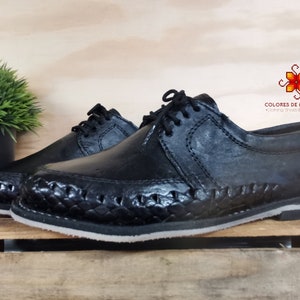 May include: Black leather shoes with a woven design on the sole. The shoes have a lace-up closure and a rounded toe. The brand name "COLORES DE MEXICO MX" is visible in the image.
