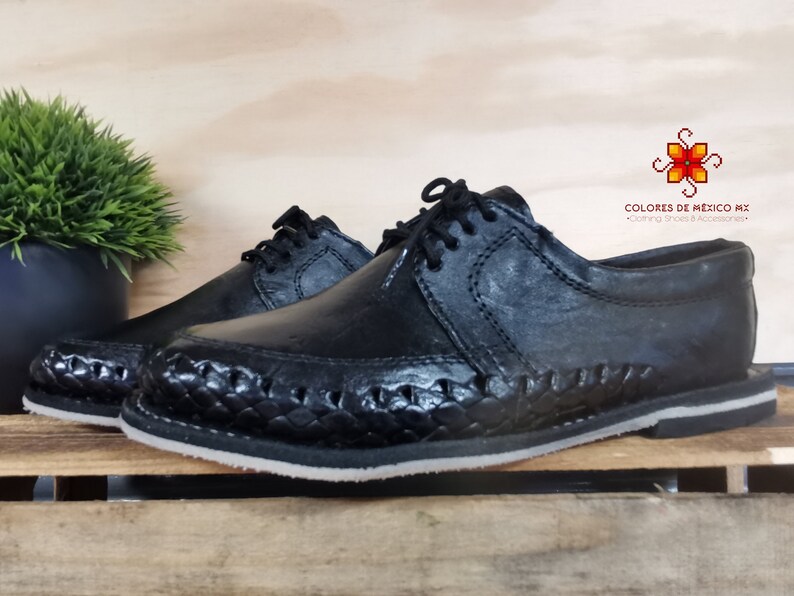 May include: Black leather shoes with a woven design on the sole. The shoes have a lace-up closure and a rounded toe. The brand name "COLORES DE MEXICO MX" is visible in the image.