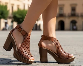 May include: Brown leather peep-toe sandals with a perforated design and a chunky heel. The sandals have a buckle closure and a platform sole. The heel height is approximately 3 inches.