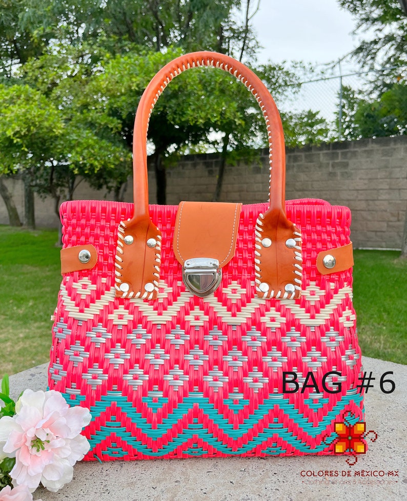 May include: A pink, white, and turquoise woven handbag with a brown leather handle and a silver clasp. The bag has a geometric pattern and the text "BAG #6" is visible on the bottom right corner.