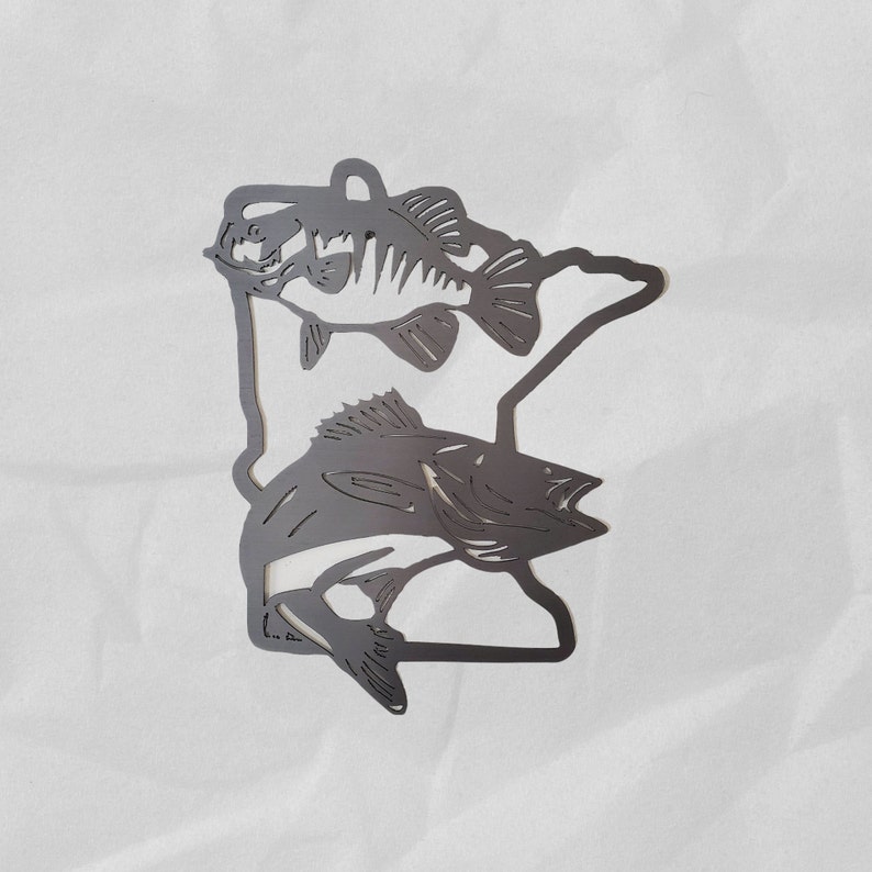 K&ouml;nnte beinhalten: Metallausschnitt des Bundesstaates Minnesota mit zwei Fischsilhouetten, einem Barsch und einem Zander.