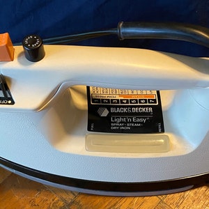 May include: A white Black & Decker Light 'n Easy spray, steam, and dry iron with a black handle and a dial for temperature control.