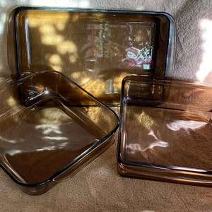 Puede incluir: Tres fuentes para hornear de vidrio marrón de diferentes tamaños. Las fuentes son de vidrio templado y tienen forma rectangular.