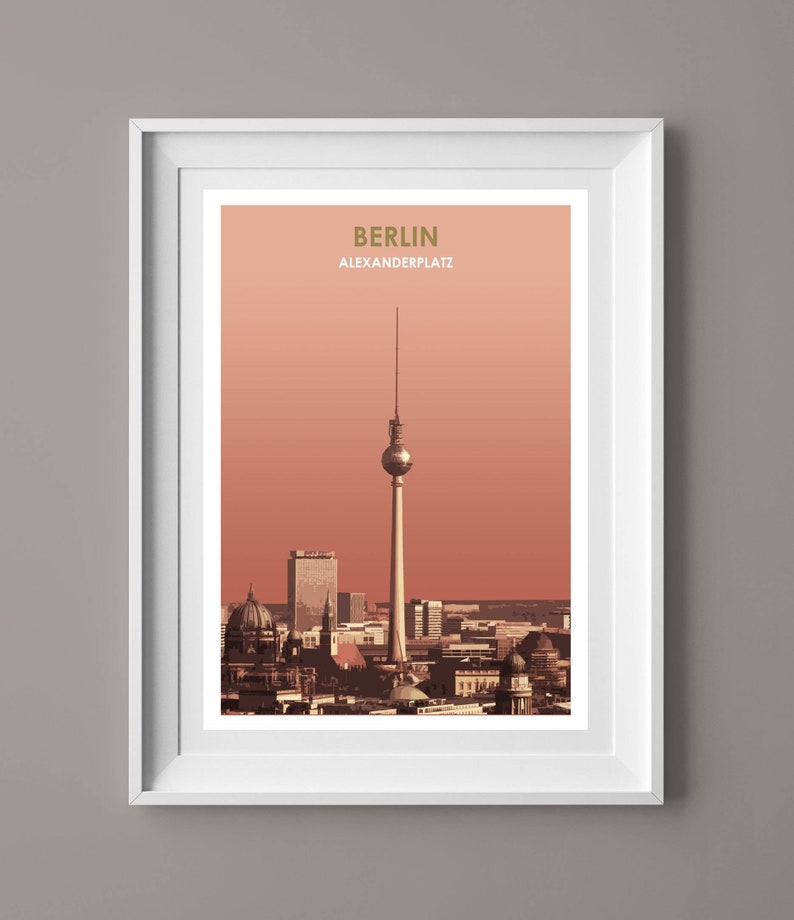 May include: A framed print of a cityscape with the Berlin Television Tower in the center. The print has a peach background and the text "BERLIN ALEXANDERPLATZ" in gold lettering.