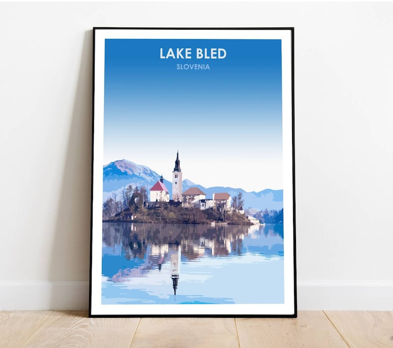 May include: A scenic poster featuring a picturesque view of Lake Bled in Slovenia. The image showcases a small island with a church and a bell tower, surrounded by clear blue water and snow-capped mountains in the background.