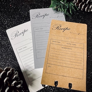 May include: Three recipe cards with a brown, gray, and white background. The cards have lines for writing down the title, prep time, ingredients, and notes for a recipe.